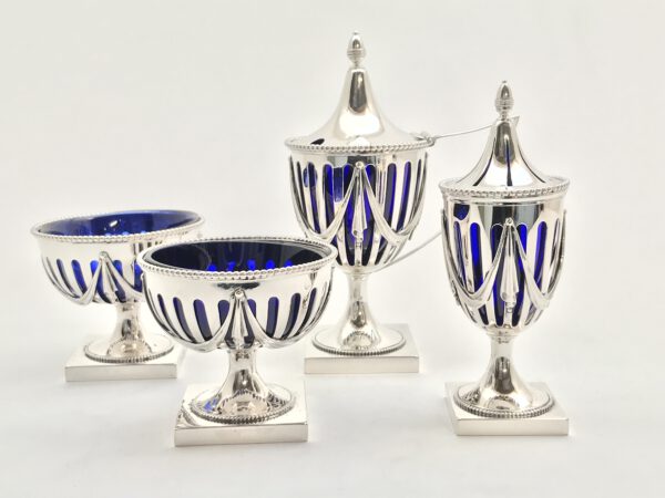 zilver vier delig tafelset bestaande uit mosterd zilver strooier, twee zoutvaatjes met blauw glas, gemaakt door outvorst uit Amsterdam in 1919, deze zilver tafelset met blauw glas kost 495 euro
